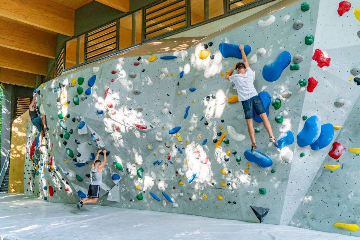 Mehrere Boulderer an der Outdoorboulderwand Thalkirchen bei Sonnenschein