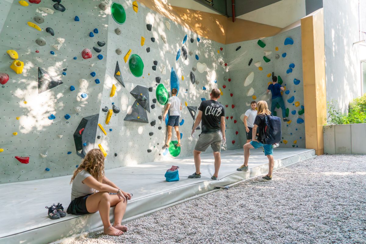 Mehrere Boulderer an der Outdoorboulderwand Thalkirchen bei Sonnenschein