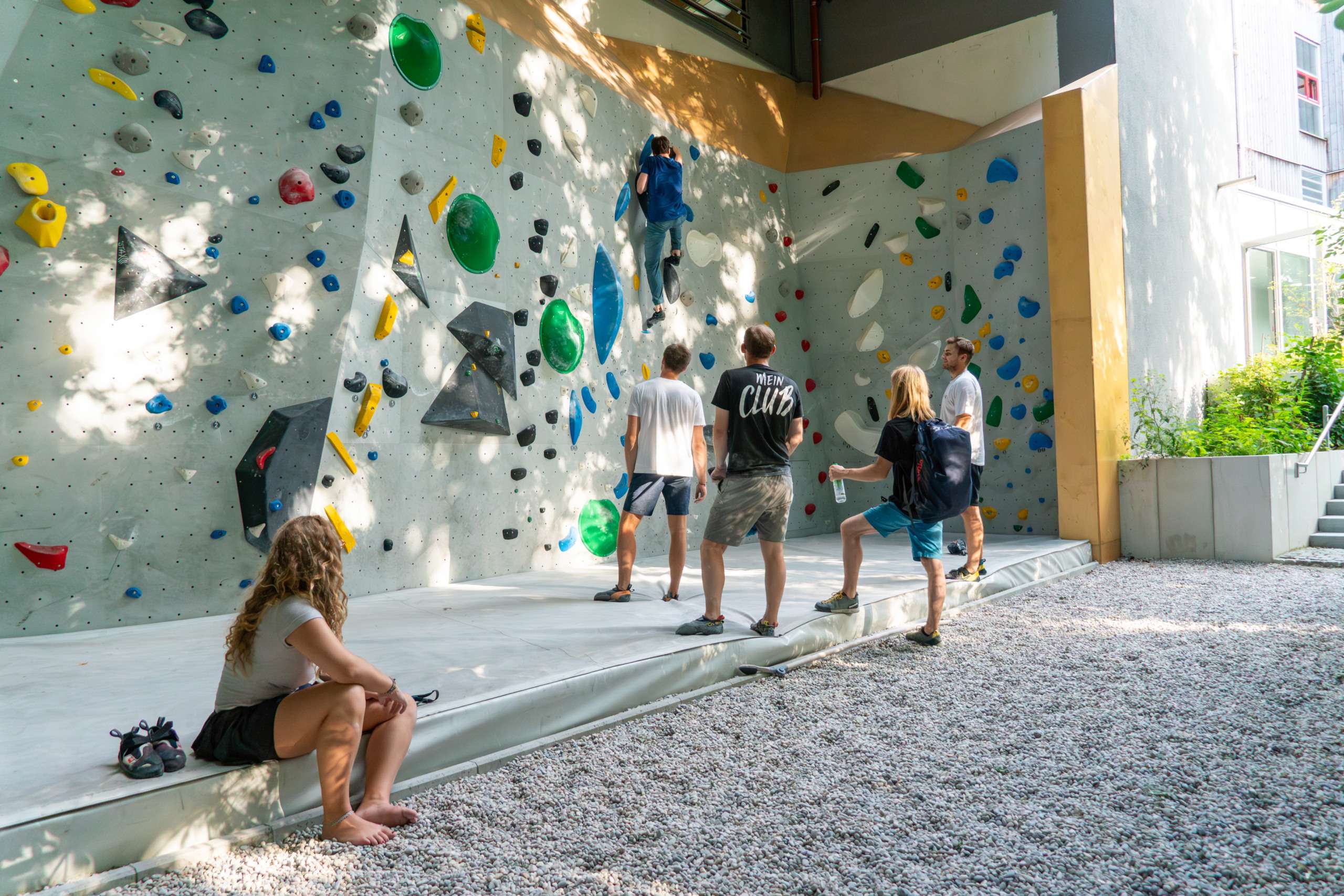 Mehrere Boulderer an der Outdoorboulderwand Thalkirchen bei Sonnenschein